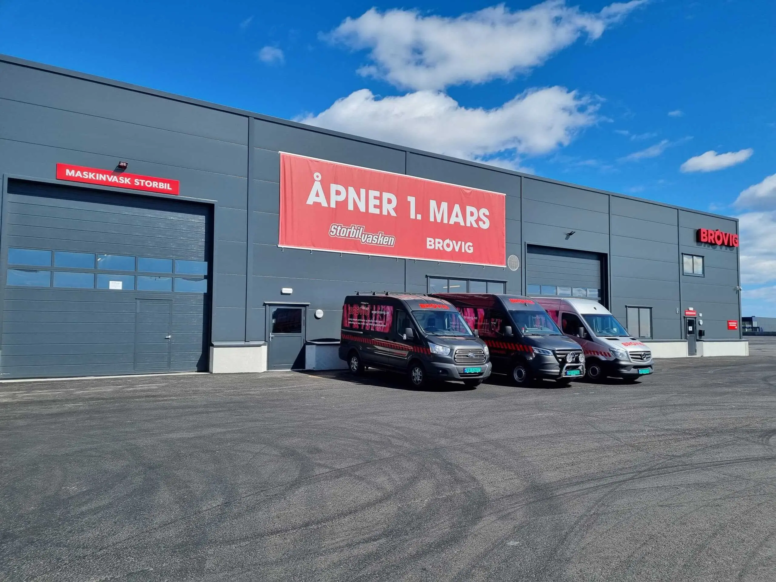 Brøvigs lokaler på Legdene 1 med banner om åpning 1. mars og tre Brøvig-servicebiler utenfor